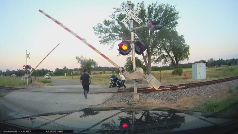 Tow truck driver helps pull motorcycle off tracks seconds before train arrives