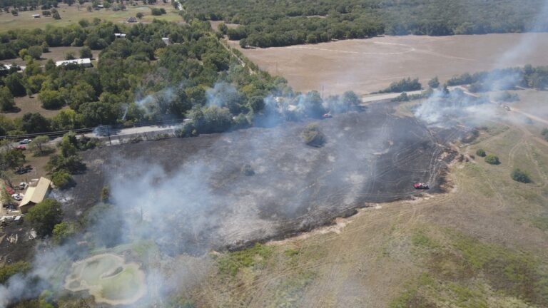 Brazos County firefighters work quickly to contain grass fire threatening structure