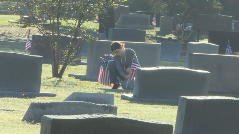 Community volunteers place flags on veteran’s graves at College Station cemetary